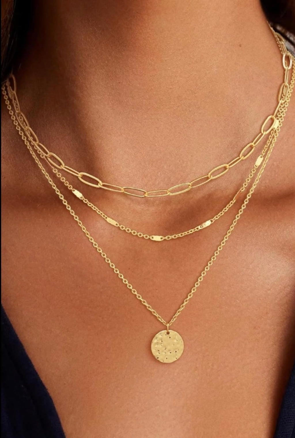 Woman wearing double layer gold paperclip and rope chain necklace