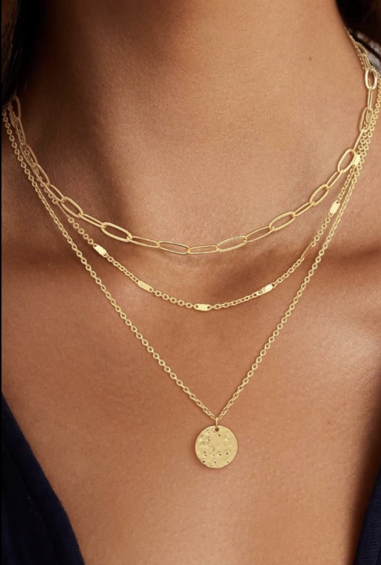 Woman wearing double layer gold paperclip and rope chain necklace