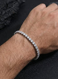 Gold tennis bracelet with cubic zirconia stones on male wrist