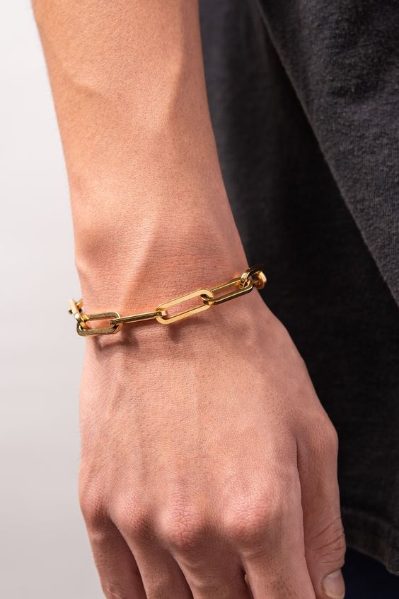 Gold paperclip link bracelet flat lay with watch