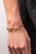 Gold paperclip link bracelet flat lay with watch