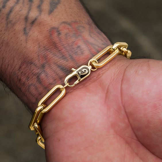 Gold paperclip link bracelet flat lay with watch