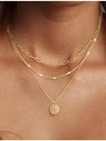 Woman wearing double layer gold paperclip and rope chain necklace
